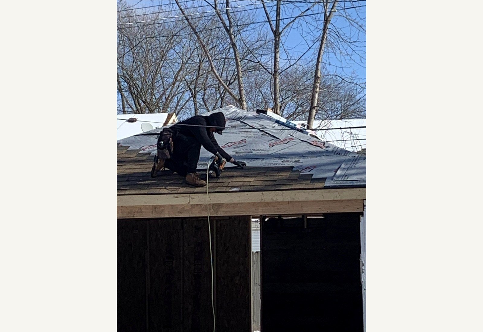Reliable Renovators garage fire damage repair progress with roof shingle installation in Metro Detroit
