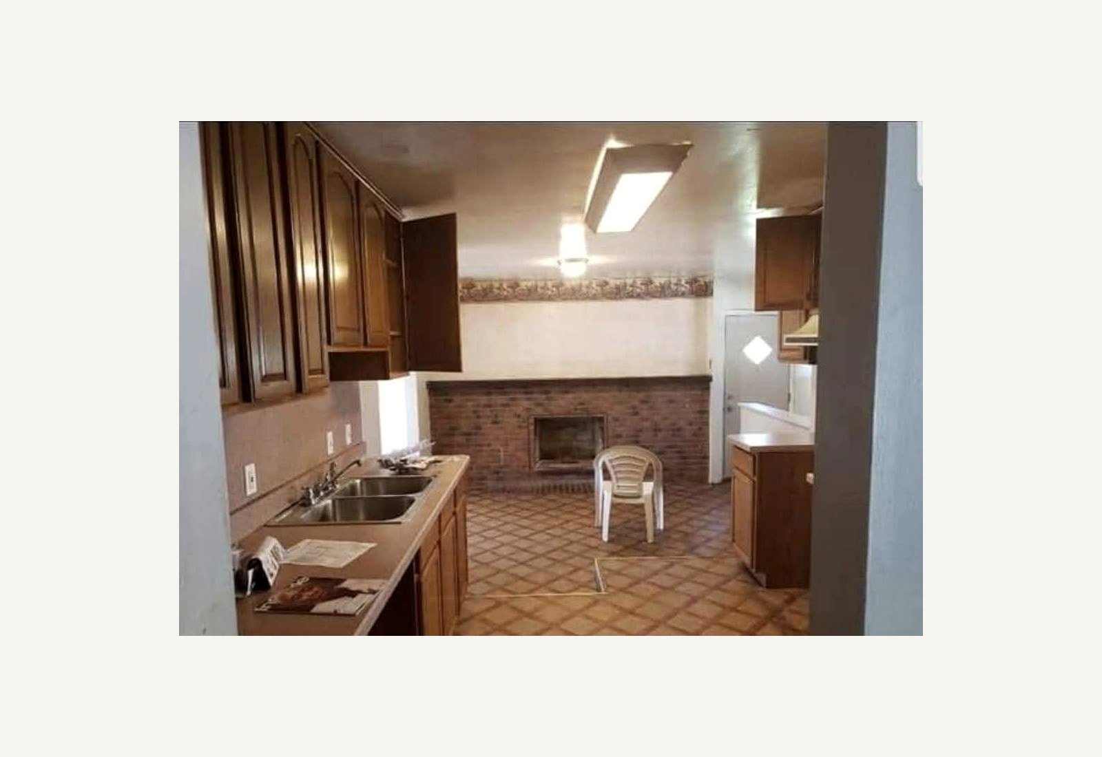 Reliable Renovators kitchen before photo with brown cabinets and fireplace area in Metro Detroit
