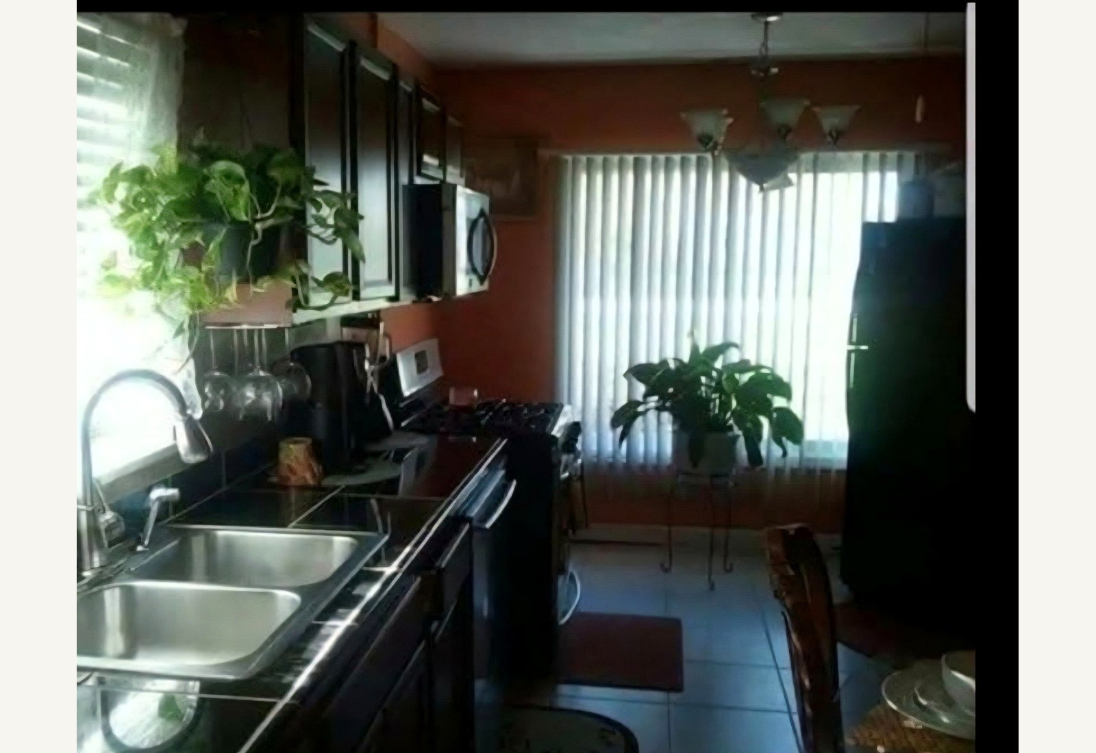 Reliable Renovators kitchen before photo with dark cabinets and orange wall in Metro Detroit