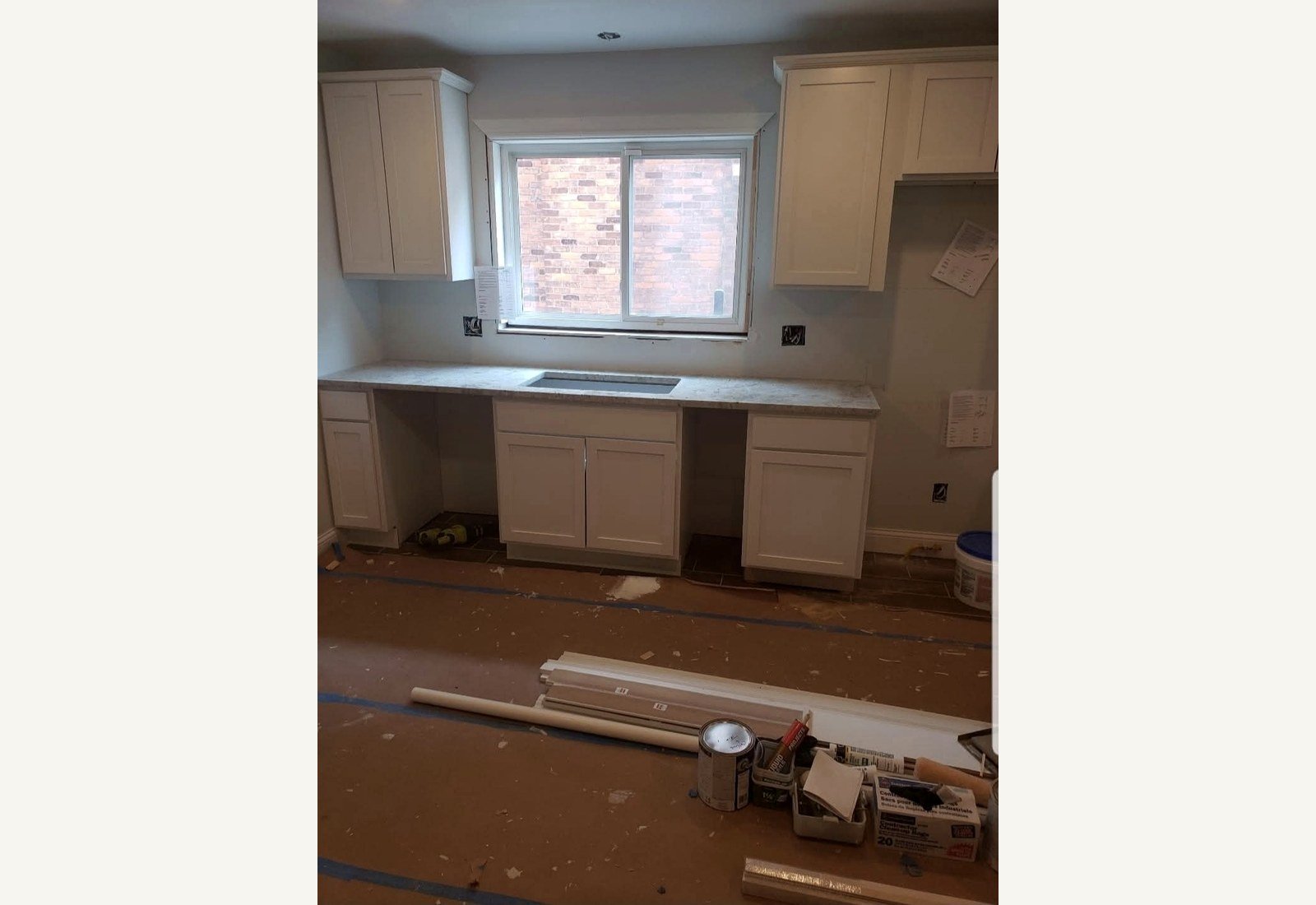 Reliable Renovators kitchen progress photo with white cabinets and countertop installation in Metro Detroit